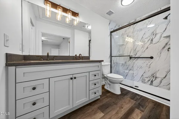 a bathroom with a double vanity sink toilet and a mirror