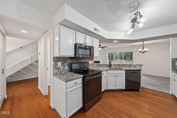 a kitchen with a sink stove and microwave