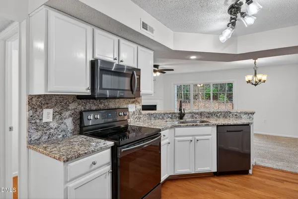 a kitchen with stainless steel appliances granite countertop a sink stove and microwave