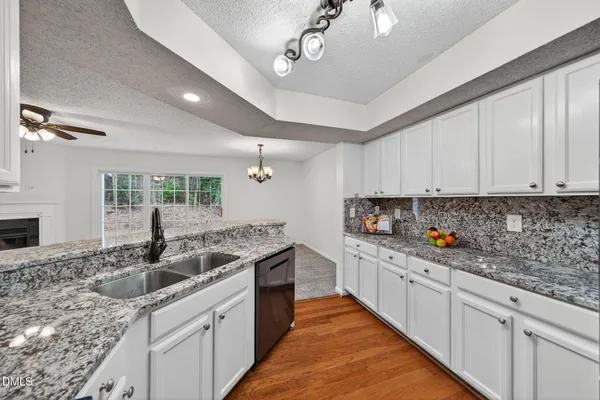 a kitchen with stainless steel appliances granite countertop a sink stove and cabinets