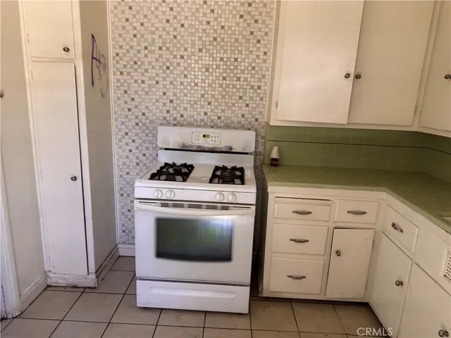 a kitchen with white cabinets and white appliances
