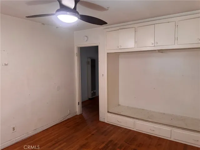 an empty room with wooden floor and closet area