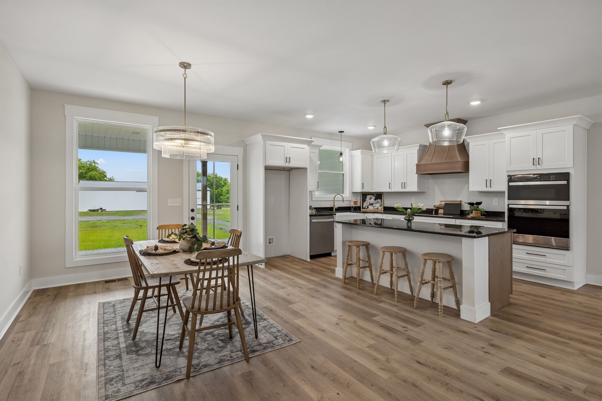 777 Rock Springs Road Castalian Springs, TN 37031 - Photo 18 of 52 a kitchen with stainless steel appliances kitchen island granite countertop a stove top oven a sink dishwasher a dining table and chairs with wooden floor