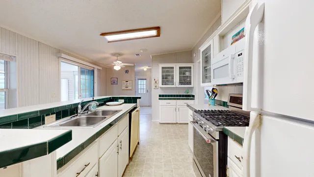 a white stove top oven sitting inside of a kitchen