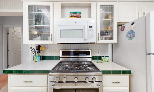 a kitchen with stainless steel appliances granite countertop a stove and cabinets