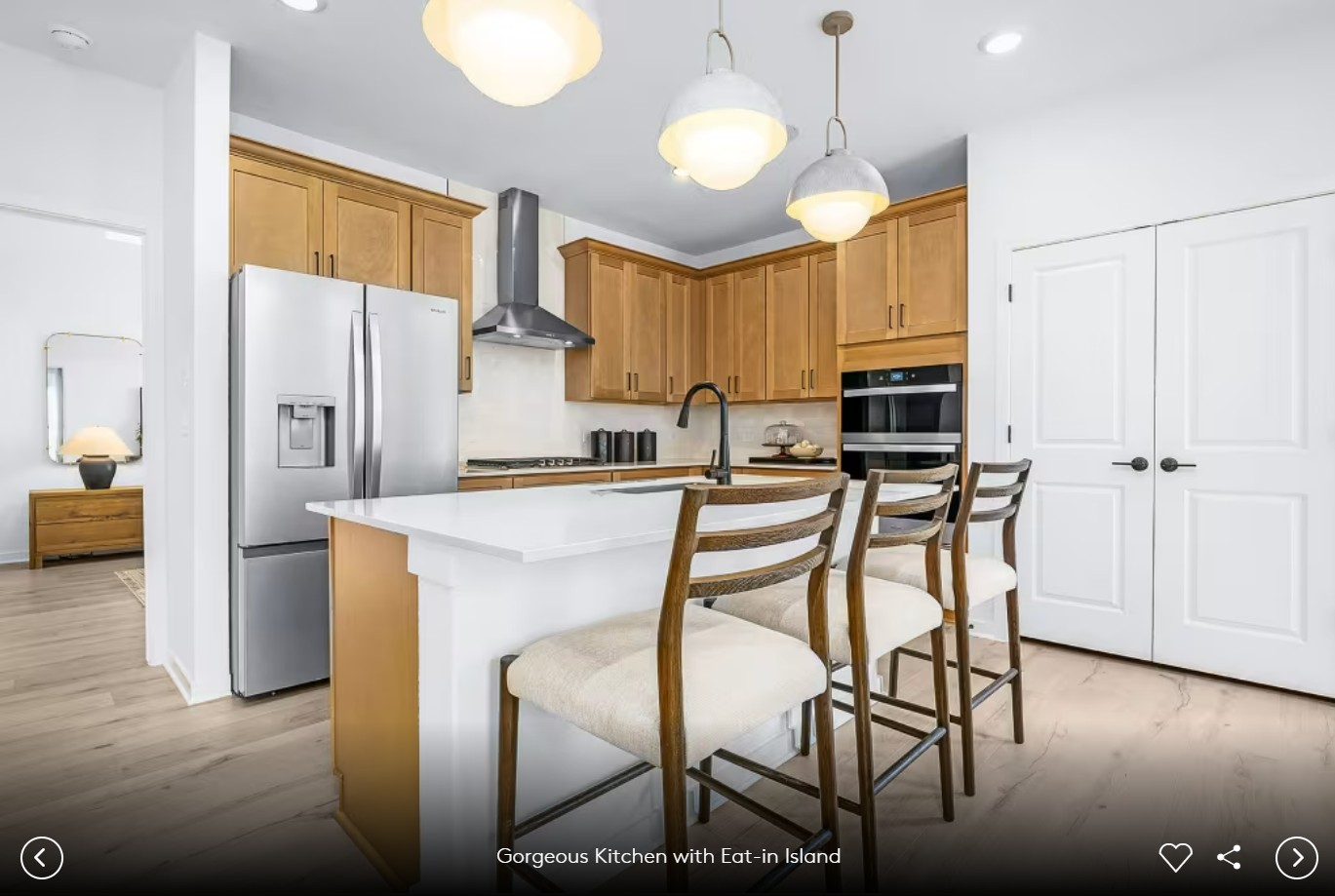 624 Rubber Tree Way Buda, TX 78610 - Photo 7 of 12 a kitchen with stainless steel appliances kitchen island granite countertop a table chairs and a refrigerator