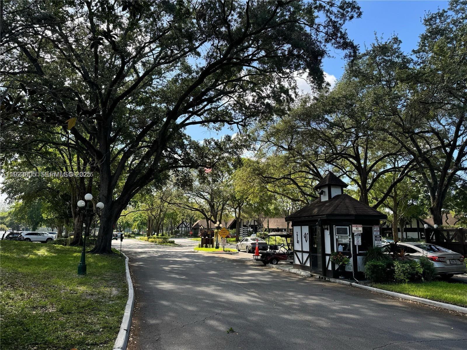 3720 Inverrary Drive, Unit 1S Lauderhill, FL 33319 - Photo 23 of 25 a street view with large trees