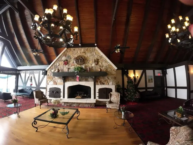 a living room with furniture a fireplace and a chandelier
