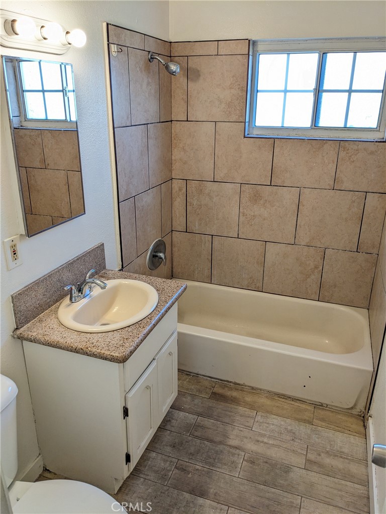 1708 Pine Avenue, Unit 11 Long Beach, CA 90813 - Photo 12 of 17 a bathroom with a granite countertop sink a toilet and bathtub