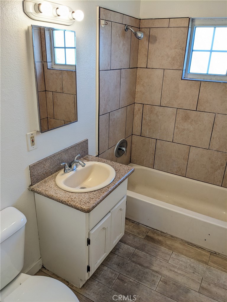 1708 Pine Avenue, Unit 11 Long Beach, CA 90813 - Photo 13 of 17 a bathroom with a granite countertop sink a toilet and bathtub