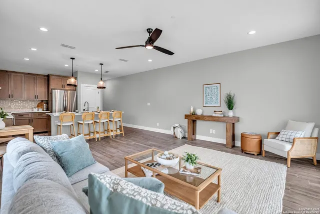 a living room with furniture kitchen view and a chandelier