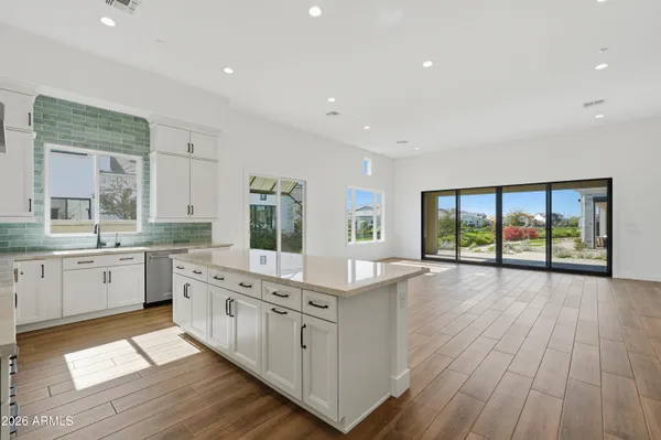 a large white kitchen with large windows and white walls
