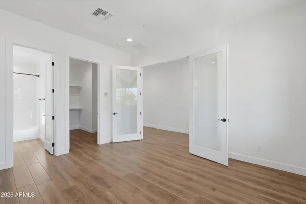 an empty room with wooden floor and windows