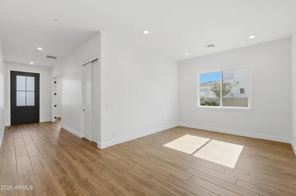 an empty room with wooden floor and windows