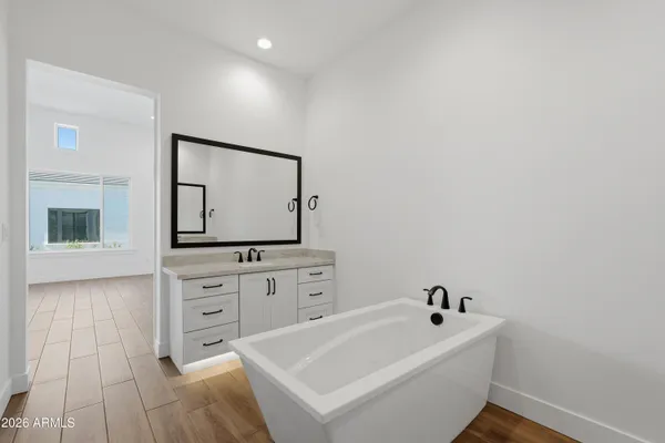 a bathroom with a bathtub sink and mirror