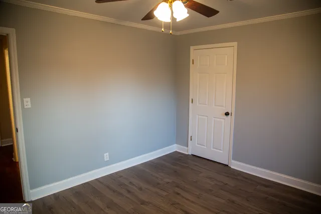 a view of an empty room with wooden floor