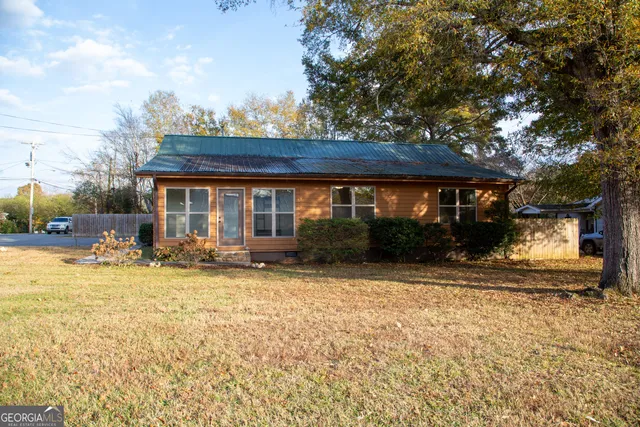 a view of a house with a yard and sitting area