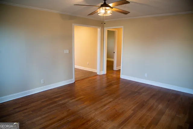a view of an empty room with wooden floor