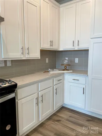a kitchen with white cabinets and sink