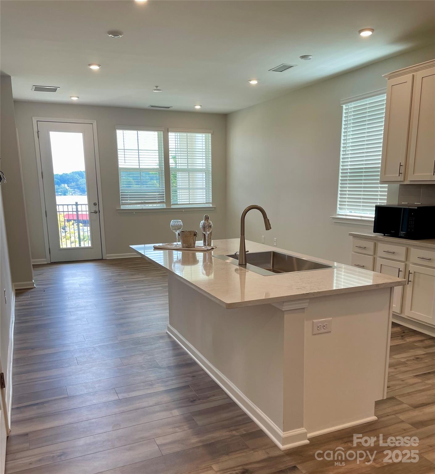 4455 Reed Crk Drive, Unit 101 Sherrills Ford, NC 28673 - Photo 9 of 34 a large kitchen with stainless steel appliances a large counter top a wooden floors and a large window