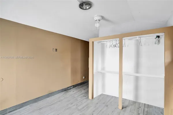 a view of an empty room with wooden floor