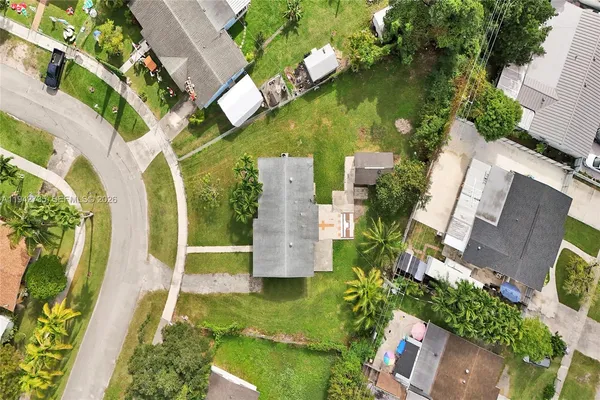 an aerial view of residential houses with outdoor space and trees