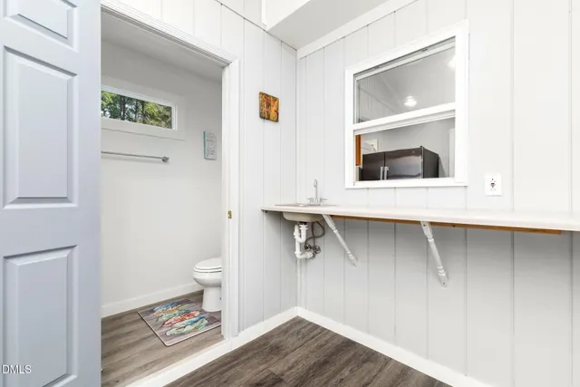 a view of a bedroom with a bed and wooden floor