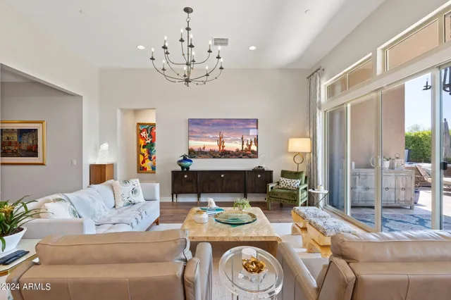 a living room with furniture a chandelier and a flat screen tv