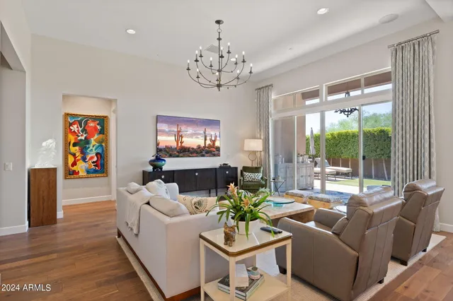 a living room with furniture a chandelier and a flat screen tv