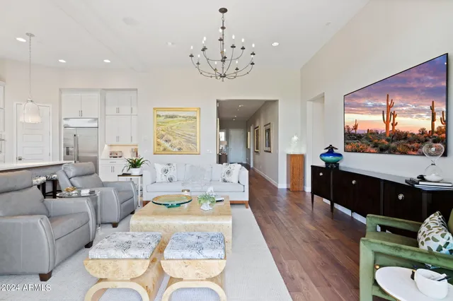 a living room with furniture chandelier and a flat screen tv