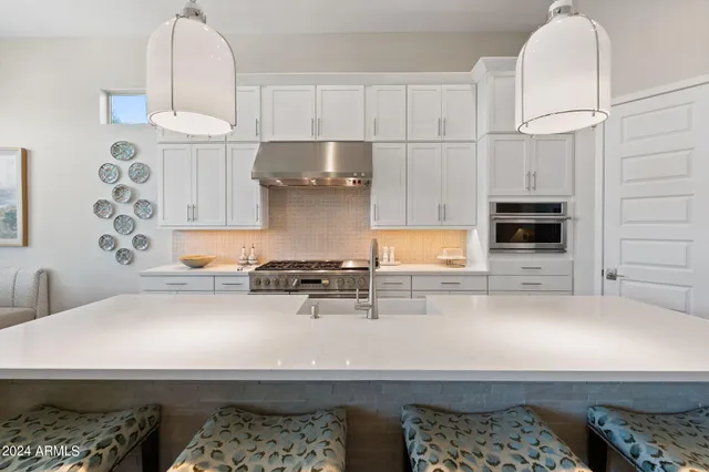 a kitchen with stainless steel appliances a white stove top oven and a white cabinets