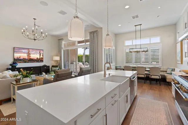 a large white kitchen with a large island in the center