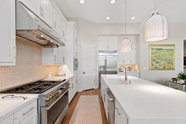 a kitchen with stainless steel appliances granite countertop a sink stove and refrigerator