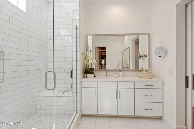 a bathroom with a double vanity sink mirror and shower