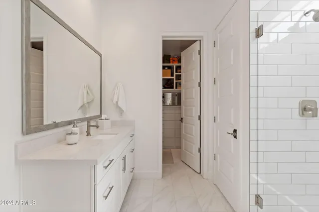 a spacious bathroom with a double vanity sink a mirror and shower