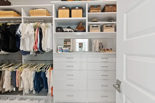 a view of walk in closet with clothes and shoes