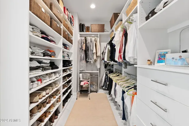 a view of walk in closet with clothes and shoes