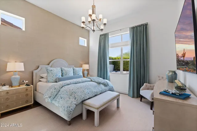 a bedroom with a bed and a chandelier