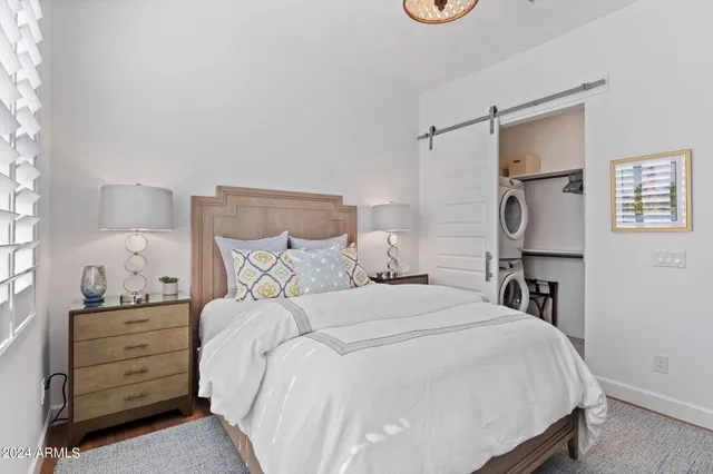 a bedroom with a bed and a lamp on the dresser