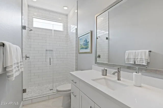 a bathroom with a granite countertop sink toilet and shower