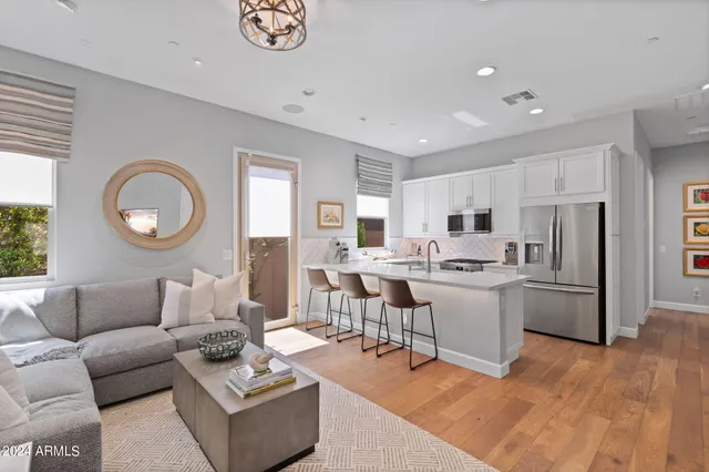 a living room with furniture kitchen view and a window