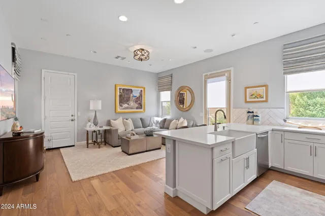 a view of a kitchen counter space a sink wooden floor and windows
