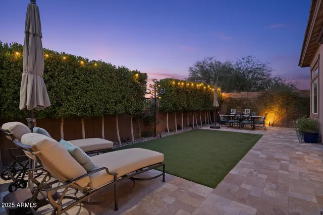 a backyard of a house with table and chairs