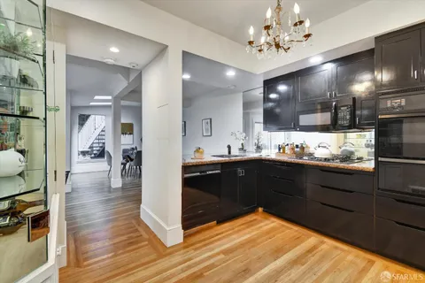 a kitchen with stainless steel appliances kitchen island granite countertop a refrigerator and cabinets