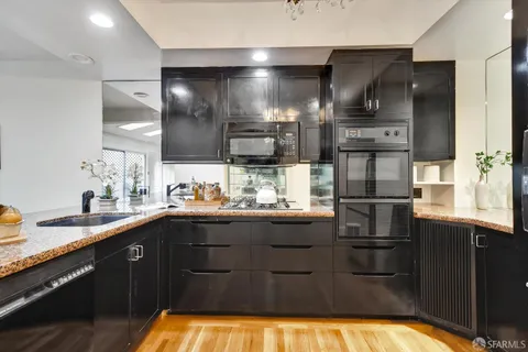 a kitchen with stainless steel appliances granite countertop a refrigerator and a sink
