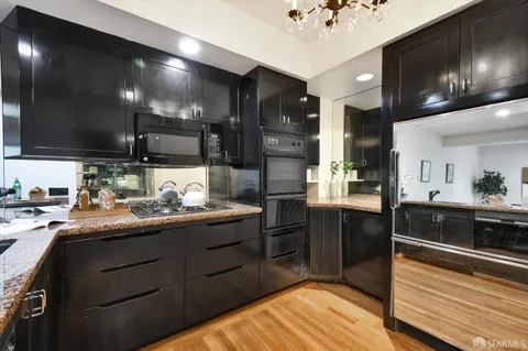 a kitchen with stainless steel appliances kitchen island granite countertop a refrigerator and a stove top oven