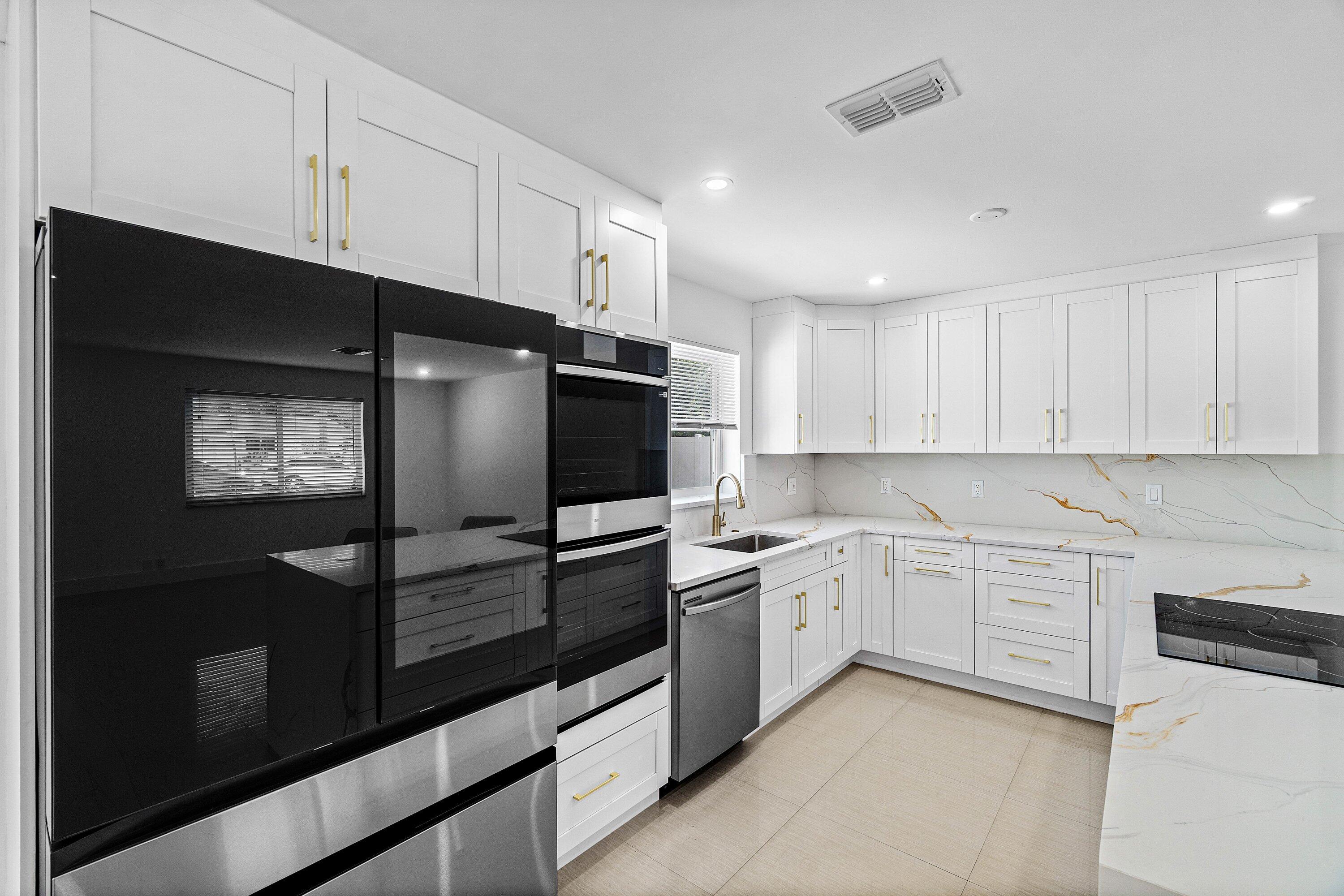 1531 Northwest 4th Street Boca Raton, FL 33486 - Photo 8 of 34 a kitchen with white cabinets and appliances