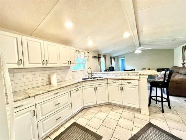 a kitchen with a dining table chairs and white appliances