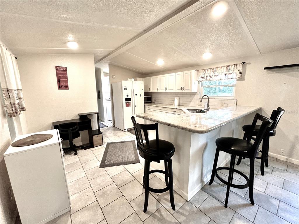 4008 77th Boulevard Jasper, FL 32052 - Photo 5 of 35 a kitchen with a dining table chairs and white appliances