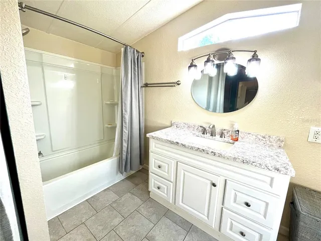 a bathroom with a granite countertop toilet sink and mirror